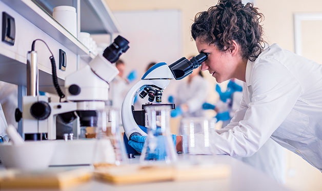 mujer usando microscopio